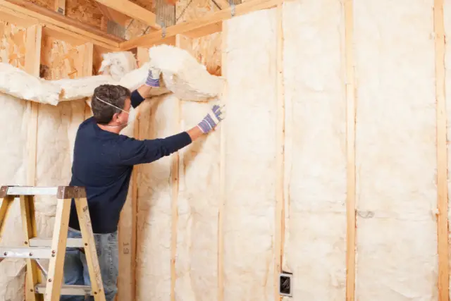 worker installing fiberglass insulation