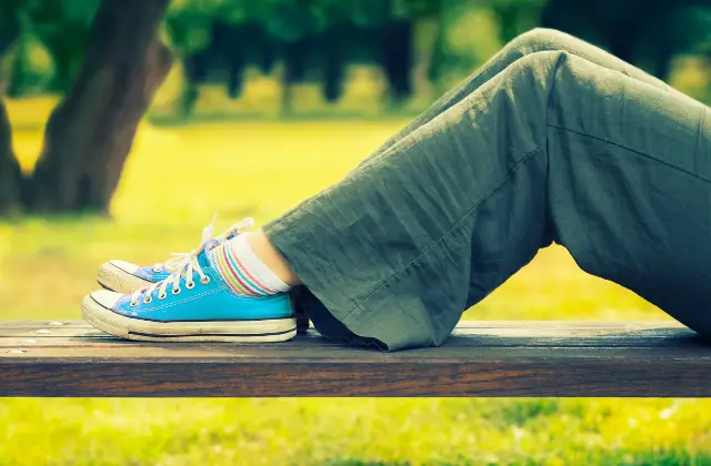 person on a bench wearing green pants - featured image